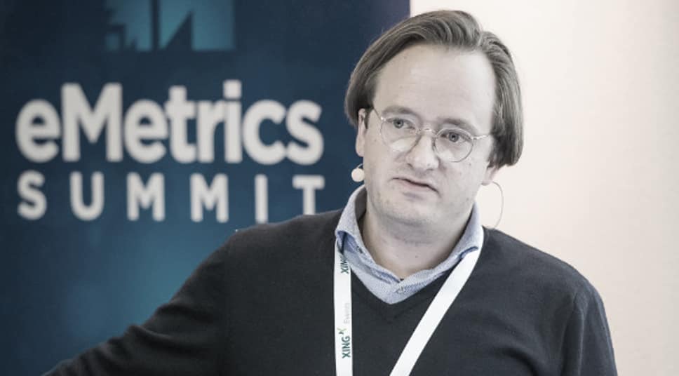 Korbinian Spann speaks at eMetrics Summit conference with attendee badge.